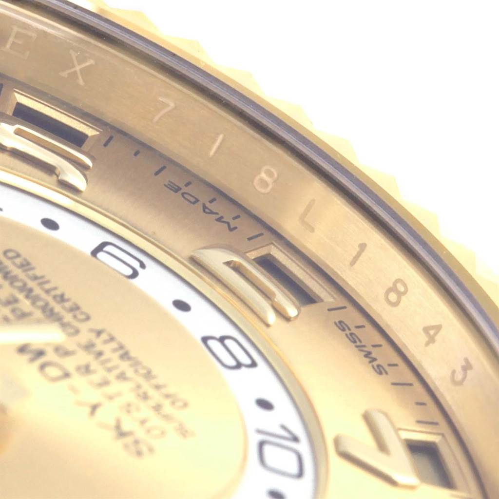The image shows a close-up of part of the dial and bezel of a Rolex Sky-Dweller 326138 Men's Yellow Gold Champagne Dial 326138 Men's Yellow Gold Champagne Dial watch, focusing on hour markers and text.