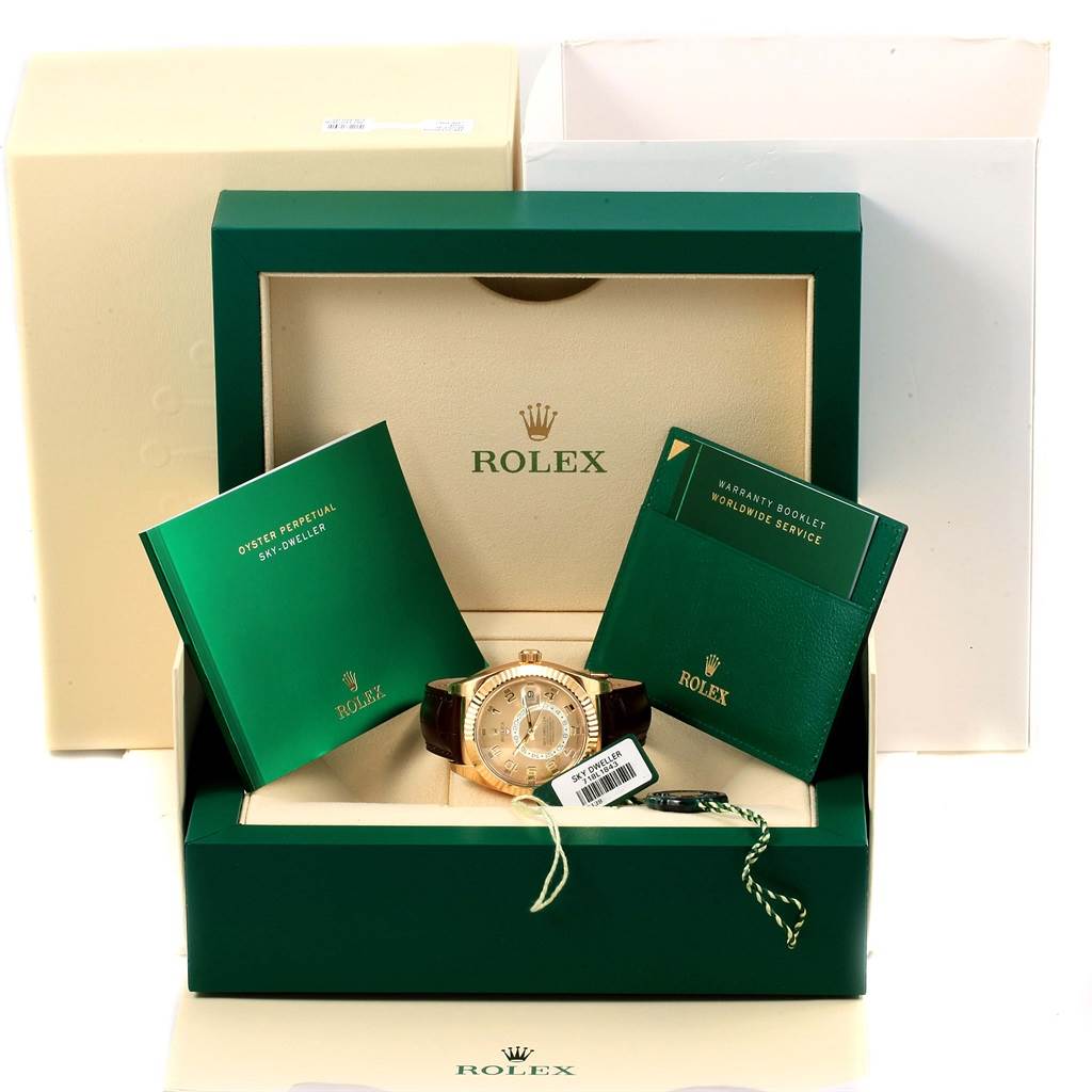 The image shows a Rolex Sky-Dweller 326138 Men's Yellow Gold Champagne Dial 326138 Men's Yellow Gold Champagne Dial watch in its original packaging, including booklets and a warranty card.