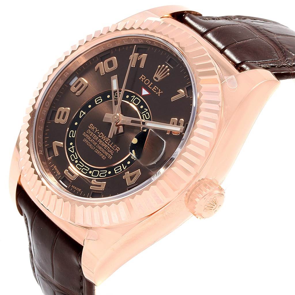 The image shows a Rolex Sky-Dweller 326135 Men's Rose Gold Brown Dial 326135 Men's Rose Gold Brown Dial watch from a side angle, highlighting its dial, bezel, crown, and leather strap.