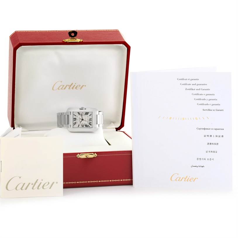 The Cartier Tank Anglaise W5310009 Men's Stainless Steel Silver Dial W5310009 Men's Stainless Steel Silver Dial watch is shown front-facing in its red and white box, with accompanying certificates and booklets placed around.