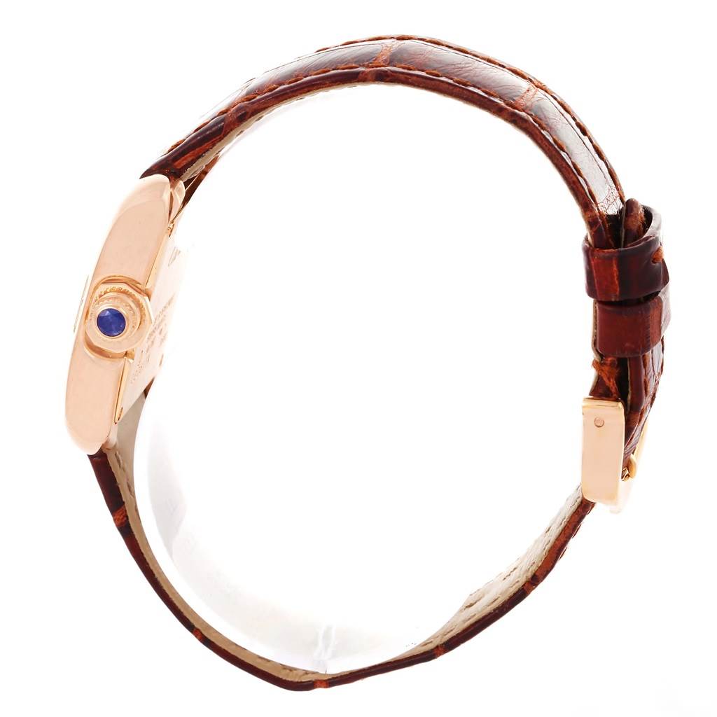 This image shows a Cartier Tank Anglaise WT100024 Women
s Rose Gold Silver Dial WT100024 Women
s Rose Gold Silver Dial model watch from a side angle, highlighting its brown leather strap and crown with a blue stone.