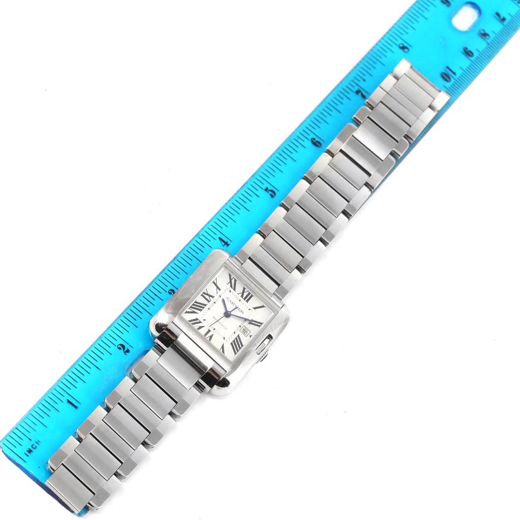 The Cartier Tank Anglaise W5310009 Men's Stainless Steel Silver Dial W5310009 Men's Stainless Steel Silver Dial watch is shown from an overhead angle, displaying its face and stainless steel bracelet against a ruler.