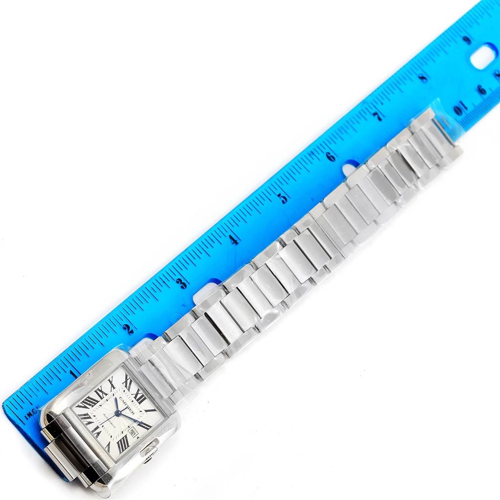 The image shows the Tank Anglaise model by Cartier from an aerial view, including the watch face and entire metal bracelet aligned with a ruler.