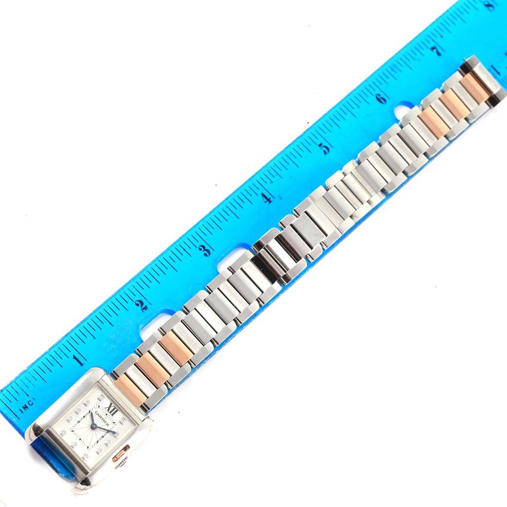 The image shows a Cartier Tank Anglaise WT100024 Women's Steel and Gold (two tone) Silver Dial WT100024 Women's Steel and Gold (two tone) Silver Dial watch laid flat next to a ruler, displaying its face and metal bracelet strap.