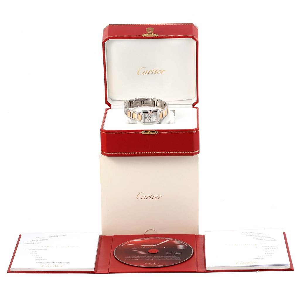 This image shows a Cartier Tank Anglaise WT100024 Women's Steel and Gold (two tone) Silver Dial WT100024 Women's Steel and Gold (two tone) Silver Dial watch in its open box, with a booklet and a CD placed below.