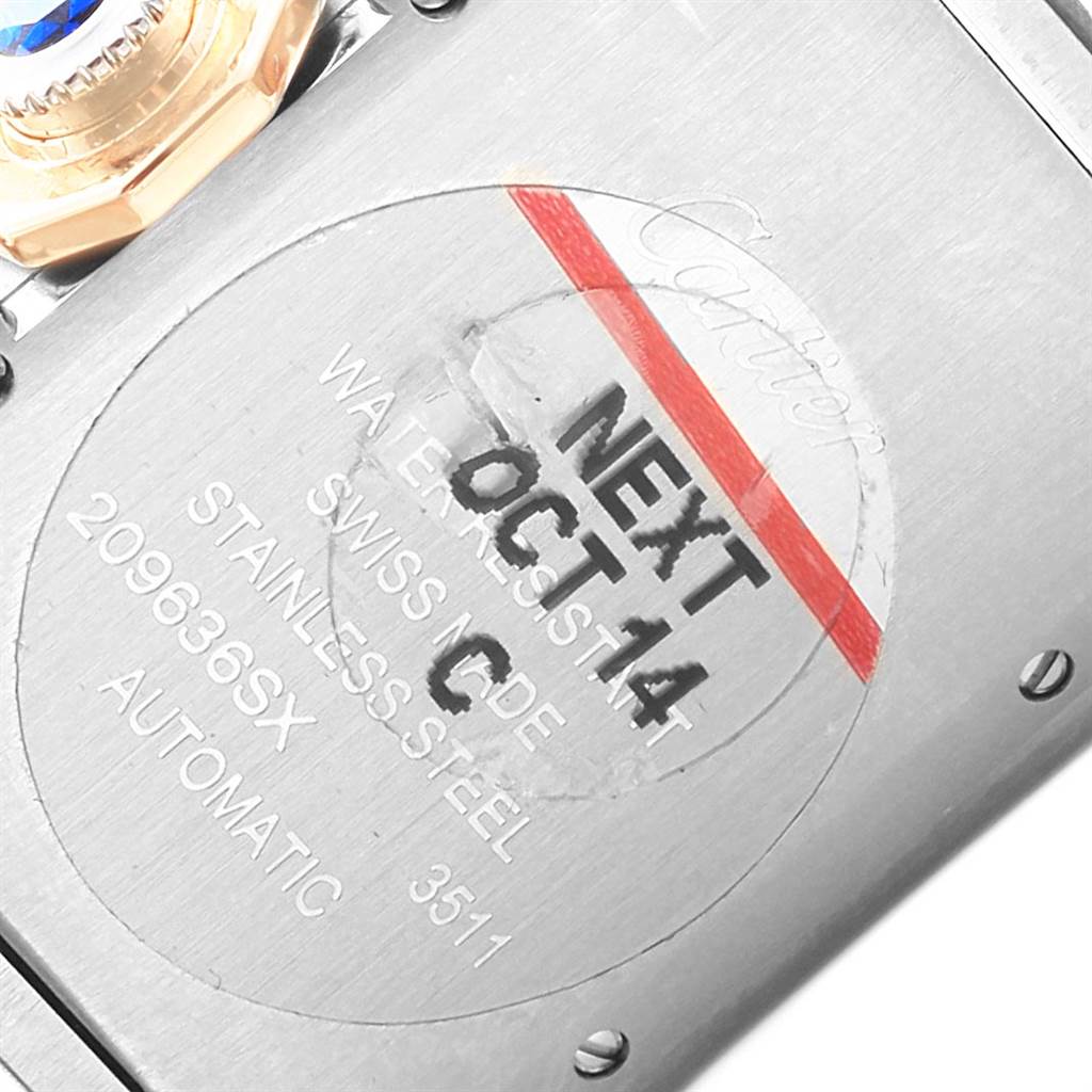 This image shows the back of a Cartier Tank Anglaise W5310007 Men's Steel and Gold (two tone) Silver Dial W5310007 Men's Steel and Gold (two tone) Silver Dial watch, highlighting the engravings and a sticker with a date.