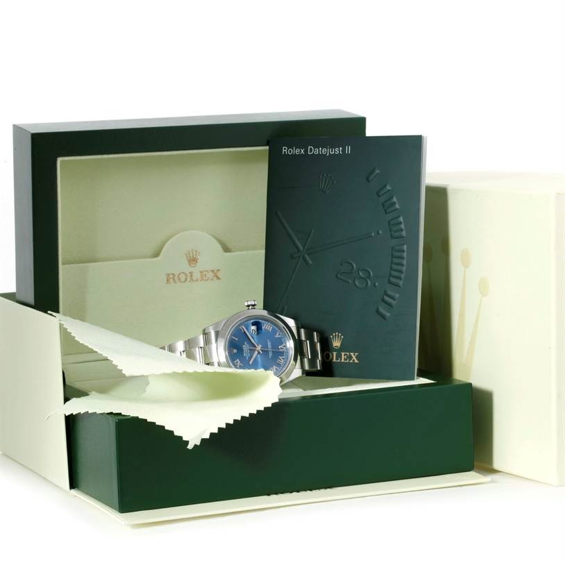 The image shows a Rolex Datejust 41 116300 Men's Stainless Steel Blue Dial 116300 Men's Stainless Steel Blue Dial watch with a blue dial, in its open box, alongside a cleaning cloth and manual.