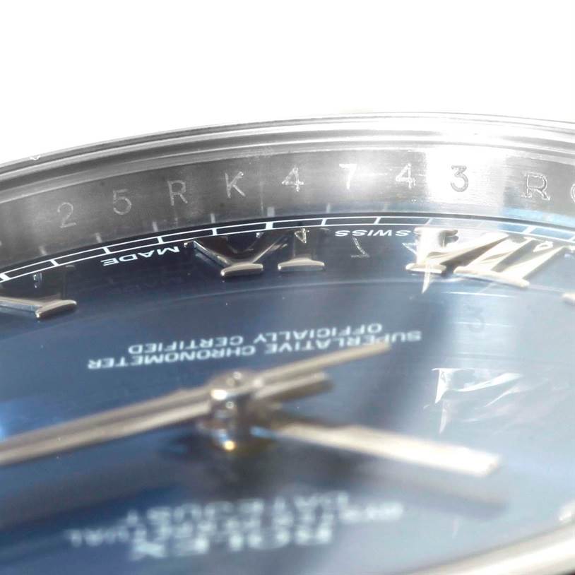 This close-up of a Rolex Datejust 41 116300 Men's Stainless Steel Blue Dial 116300 Men's Stainless Steel Blue Dial watch shows part of the dial, the hour markers, and a section of the rehaut with engraved characters.
