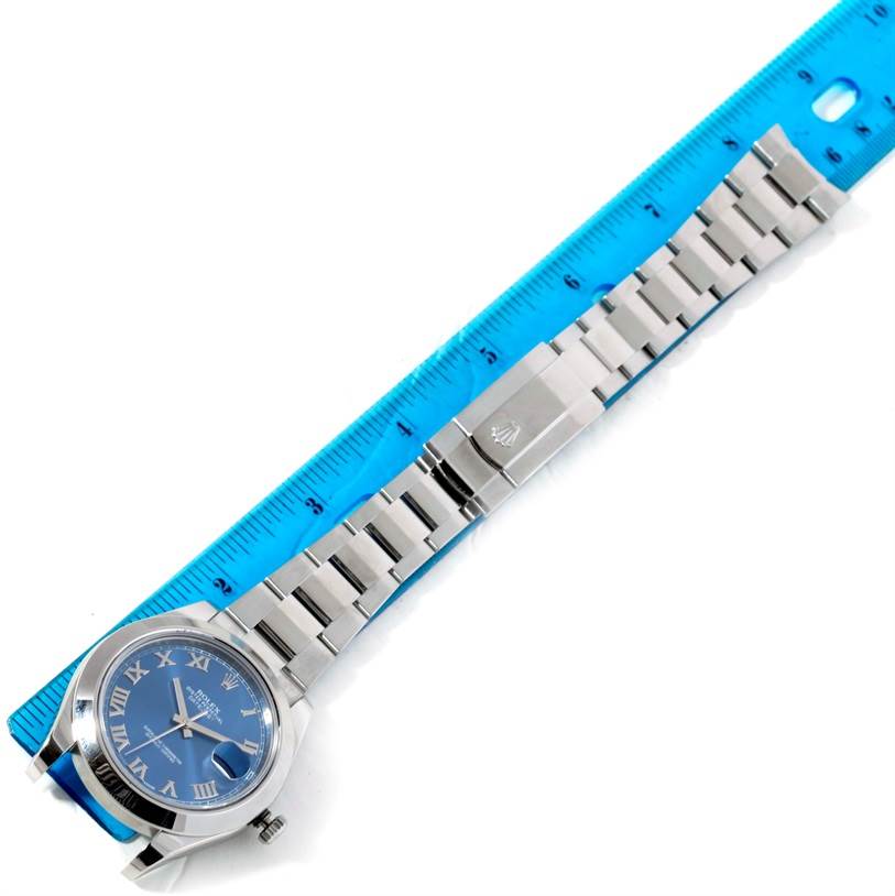 The image shows a top-down view of a Rolex Datejust 41 116300 Men's Stainless Steel Blue Dial 116300 Men's Stainless Steel Blue Dial watch, displaying its face, bezel, bracelet, and clasp next to a ruler.