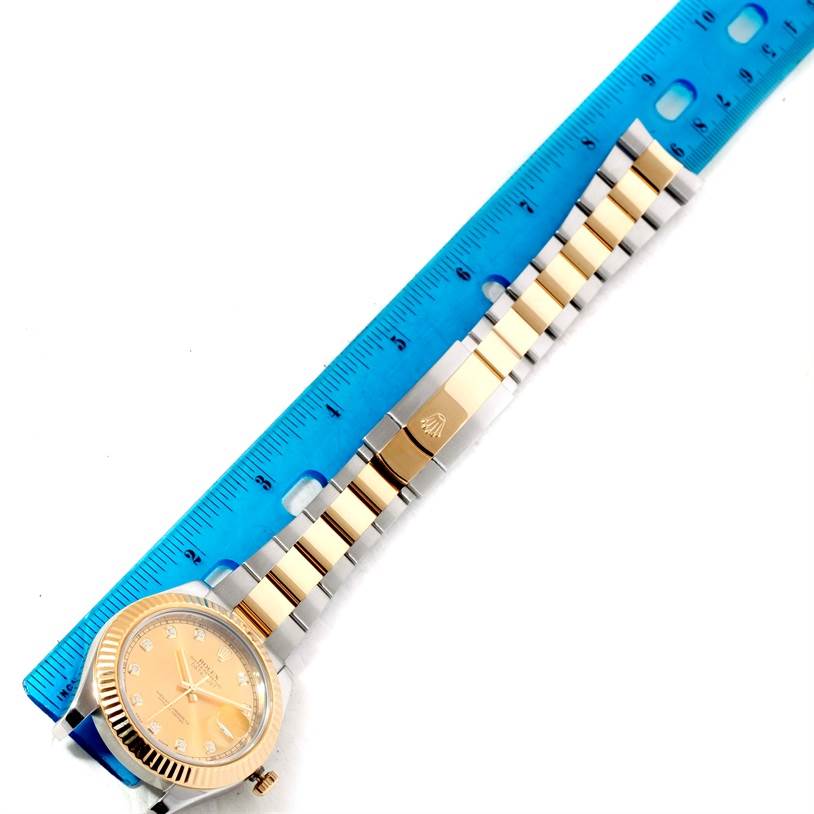 An overhead view is shown of the Rolex Datejust 41 116333 Men's Steel and Gold (two tone) Champagne Dial 116333 Men's Steel and Gold (two tone) Champagne Dial, including the face, bezel, and bracelet laid next to a blue ruler.