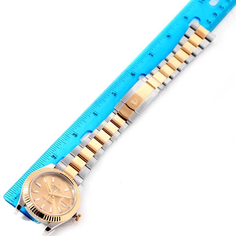 The Rolex Datejust 41 116333CSO Men's Steel and Gold (two tone) Champagne Dial 116333CSO Men's Steel and Gold (two tone) Champagne Dial watch is shown from a top-down angle, displaying its face, bezel, and bracelet against a blue ruler.