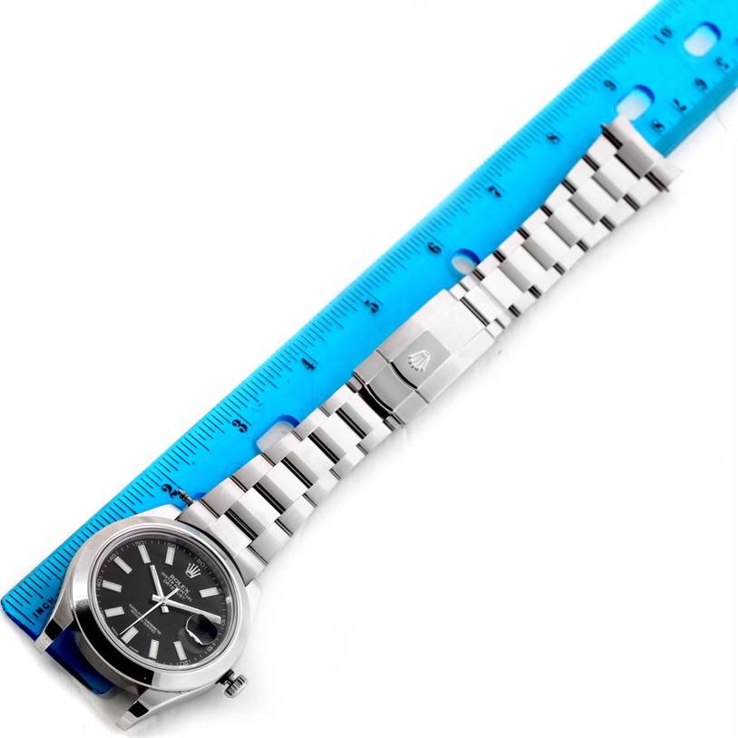 The image shows a top view of a Rolex Datejust 41 116300 Men's Stainless Steel Black Dial 116300 Men's Stainless Steel Black Dial watch laid out with a blue ruler beside it for scale.