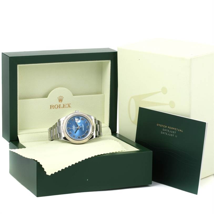 The image shows a Rolex Datejust 41 116334BLRO Men's Stainless Steel Blue Dial 116334BLRO Men's Stainless Steel Blue Dial watch with a blue dial, displayed in an open green and beige box, with accompanying documents.