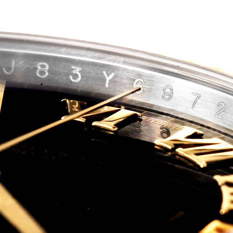 This close-up shot of the Rolex Datejust 41 116333 Men's Steel and Gold (two tone) Black Dial 116333 Men's Steel and Gold (two tone) Black Dial model shows part of the dial, hands, and the engraved serial number.
