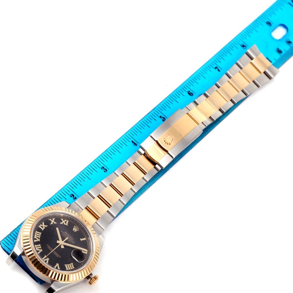 A Rolex Datejust 41 116333 Men's Steel and Gold (two tone) Black Dial 116333 Men's Steel and Gold (two tone) Black Dial watch is shown at an overhead angle, featuring its face, bezel, and two-tone bracelet with a blue ruler for scale.