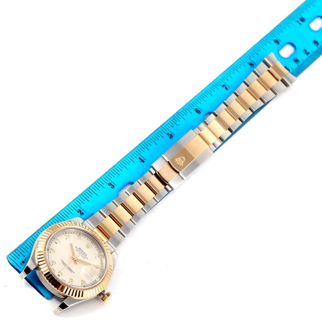 The Rolex Datejust 41 116333 Men's Steel and Gold (two tone) Beige Dial 116333 Men's Steel and Gold (two tone) Beige Dial watch is shown from a top-down angle, highlighting the face, bezel, and bracelet next to a ruler.