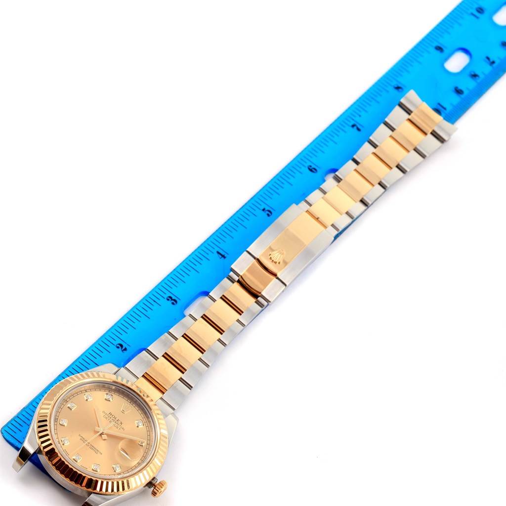 The image shows a Datejust 41 model by Rolex from a top-down angle, highlighting its gold and silver bracelet and clasp next to a ruler.