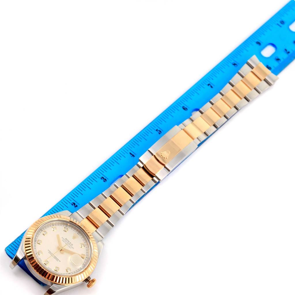 The image shows a Rolex Datejust 41 116333 Men
s Steel and Gold (two tone) Beige Dial 116333 Men
s Steel and Gold (two tone) Beige Dial watch placed vertically next to a blue ruler, displaying its face, bezel, and bracelet.