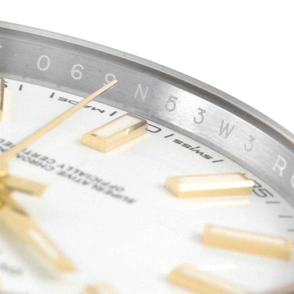 This close-up image of the Rolex Datejust 41 126303 Men's Steel and Gold (two tone) White Dial 126303 Men's Steel and Gold (two tone) White Dial displays the dial, hands, and part of the inner bezel with serial engravings.