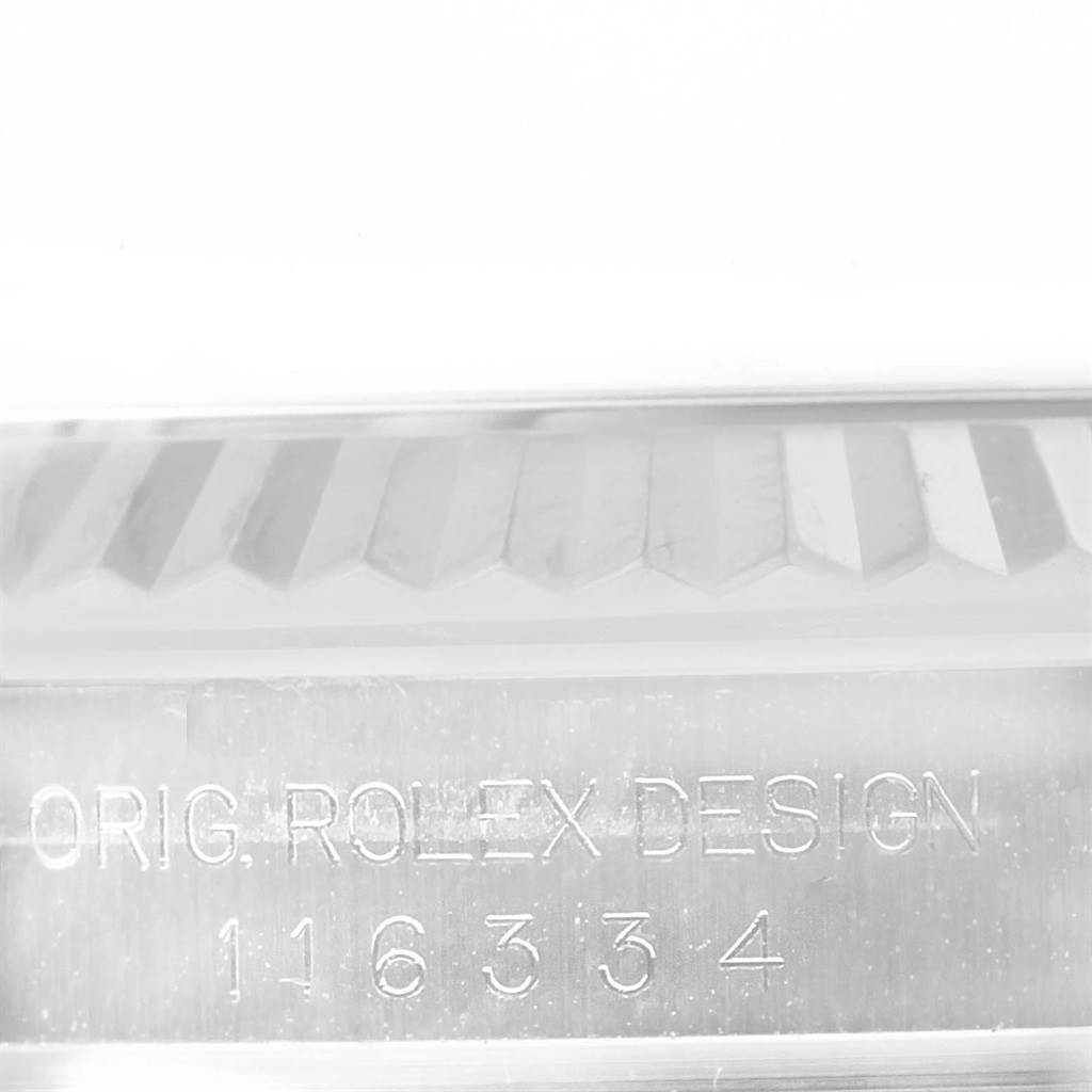 The image shows a close-up of the engraved serial number and part of the fluted bezel of the Rolex Datejust 41 116334 Men's Stainless Steel Black Dial 116334 Men's Stainless Steel Black Dial model.