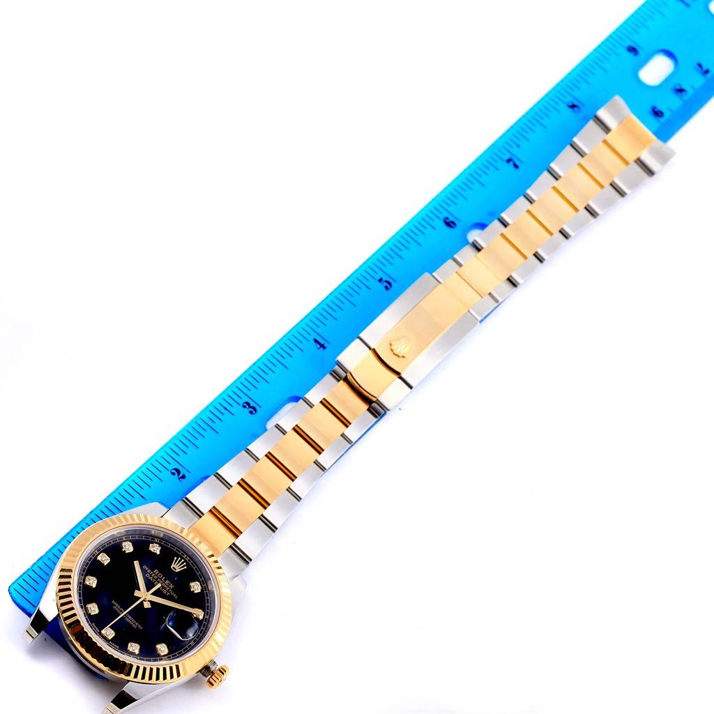 The image shows a Rolex Datejust 41 126333 Men's Steel and Gold (two tone) Black Dial 126333 Men's Steel and Gold (two tone) Black Dial watch laying flat, displaying its face, bezel, and full bracelet against a blue measuring tape.