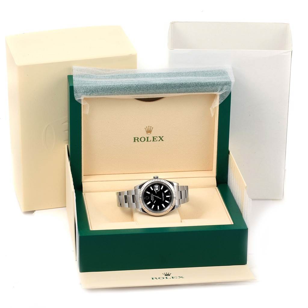 The image shows a front view of a Rolex Datejust 41 116334 Men
s Stainless Steel Black Dial 116334 Men
s Stainless Steel Black Dial watch in its opened green and beige box with additional packaging.