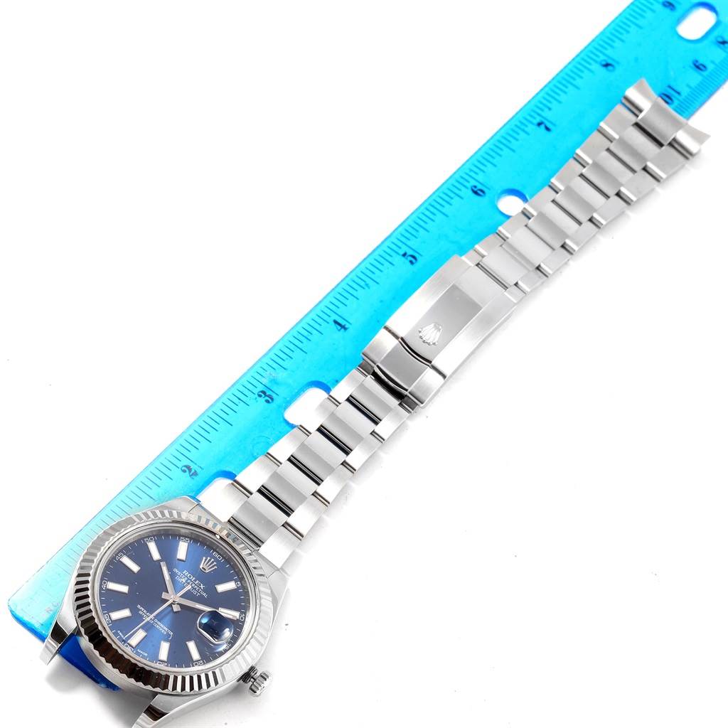 The image shows a Rolex Datejust 41 116334 Men's Stainless Steel Blue Dial 116334 Men's Stainless Steel Blue Dial watch laid flat with its bracelet extended next to a ruler for scale.