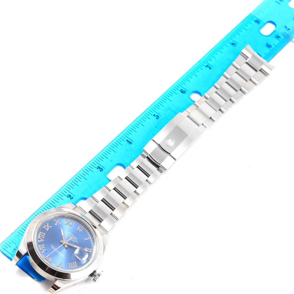 The image shows a top view of a Rolex Datejust 41 116300 Men's Stainless Steel Blue Dial 116300 Men's Stainless Steel Blue Dial watch with a blue dial and full metal bracelet, measured against a blue ruler.