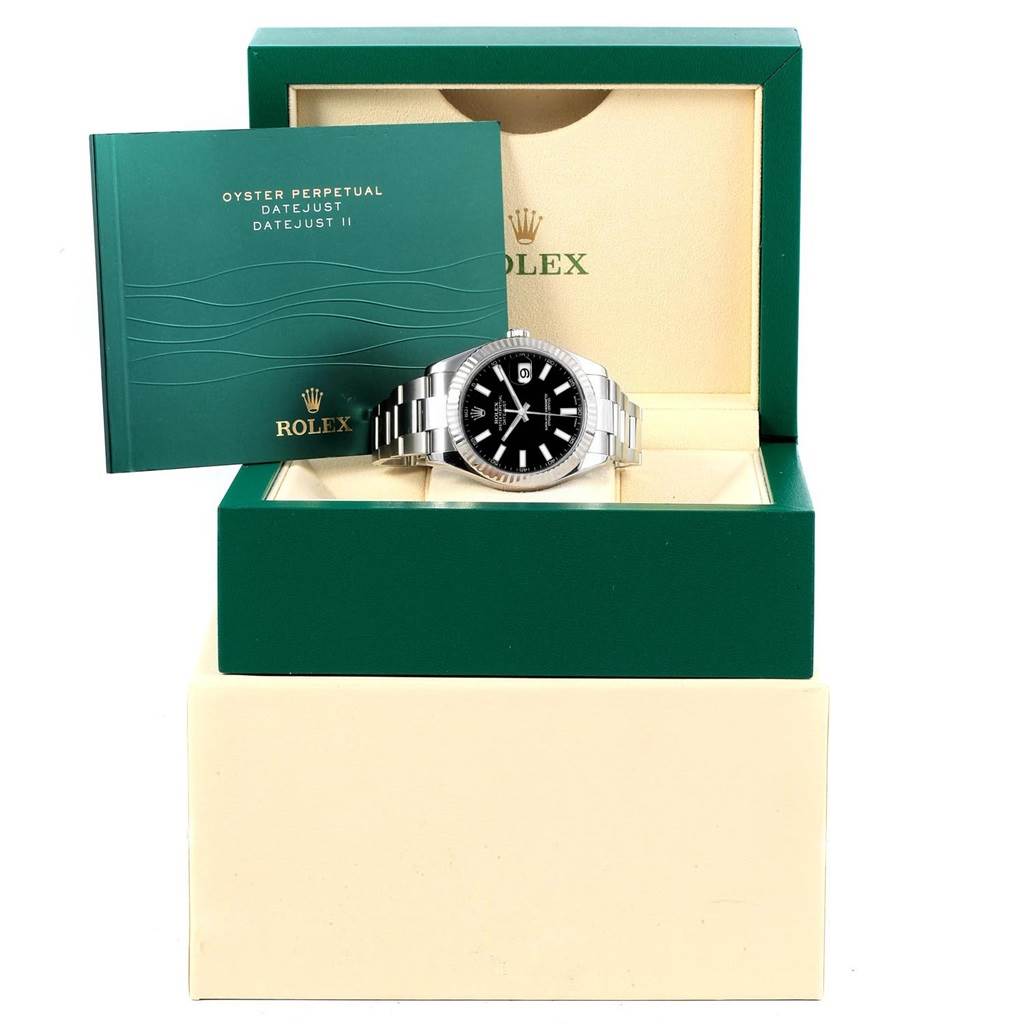 The Rolex Datejust 41 116334 Men's Stainless Steel Black Dial 116334 Men's Stainless Steel Black Dial watch is displayed from the front within an open green box alongside its instruction manual.