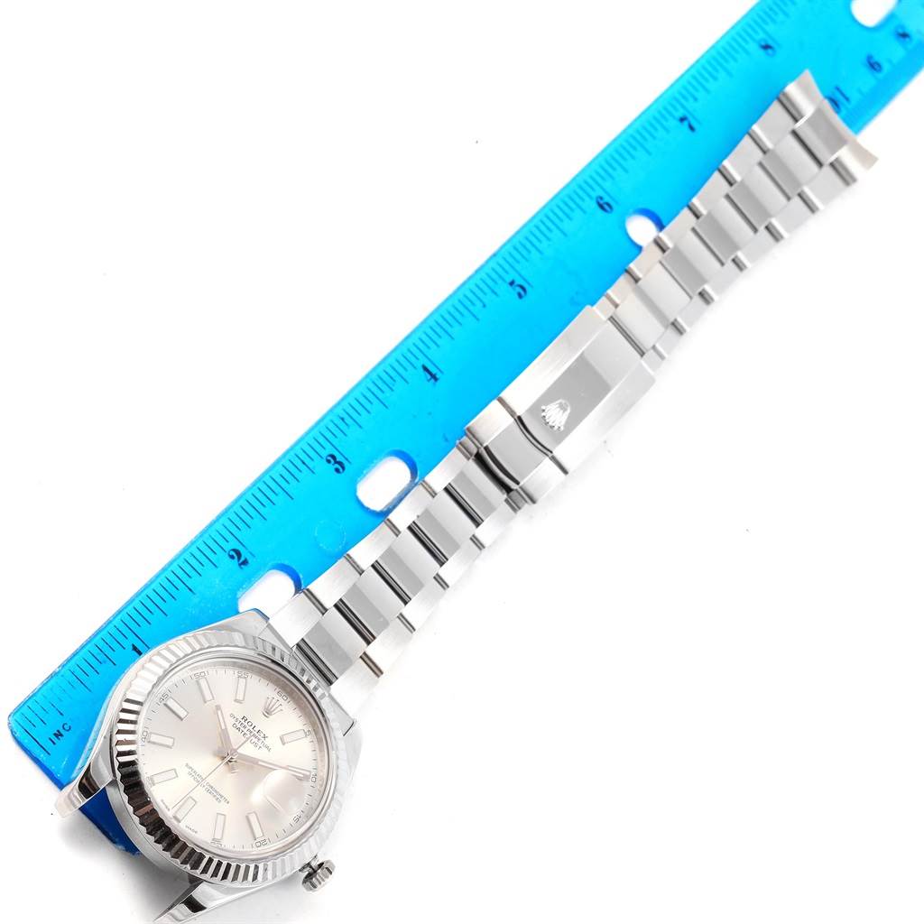 The image shows a Rolex Datejust 41 116334 Men's Stainless Steel Silver Dial 116334 Men's Stainless Steel Silver Dial watch laid flat next to a blue ruler, revealing part of the face and the entire bracelet.