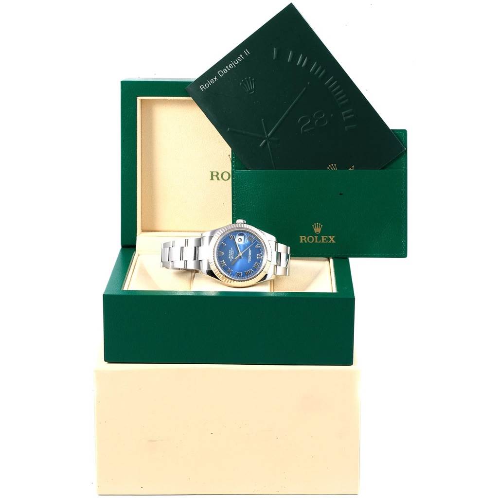 The Rolex Datejust 41 116334 Men's Stainless Steel Blue Dial 116334 Men's Stainless Steel Blue Dial watch is displayed in its open green box, with a booklet positioned behind it.