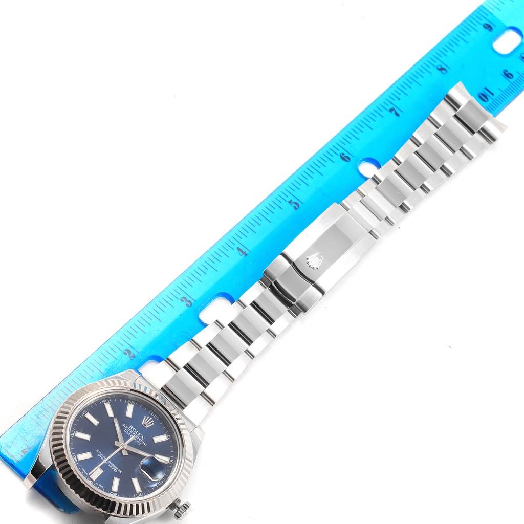 The image shows a top view of the Rolex Datejust 41 116334 Men's Stainless Steel Blue Dial 116334 Men's Stainless Steel Blue Dial watch, highlighting the face, bezel, and bracelet next to a ruler.