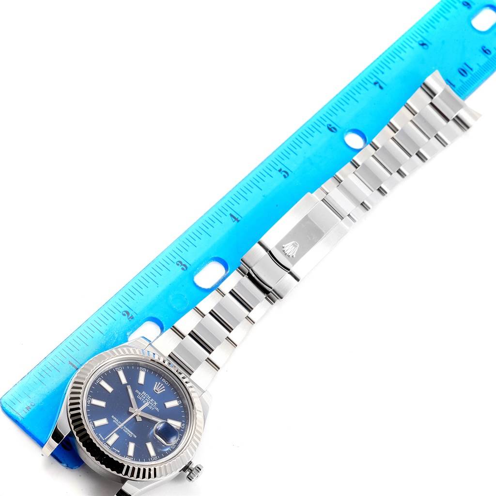 The Rolex Datejust 41 116334 Men's Stainless Steel Blue Dial 116334 Men's Stainless Steel Blue Dial watch is positioned flat with a blue ruler showing its length; it displays the face, bezel, and metal bracelet.