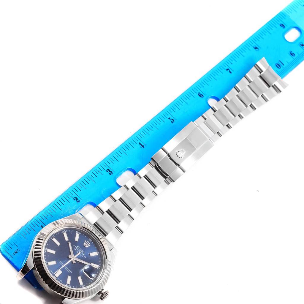 This photo shows the Rolex Datejust 41 116334 Men's Stainless Steel Blue Dial 116334 Men's Stainless Steel Blue Dial watch lying flat with a blue ruler for scale.