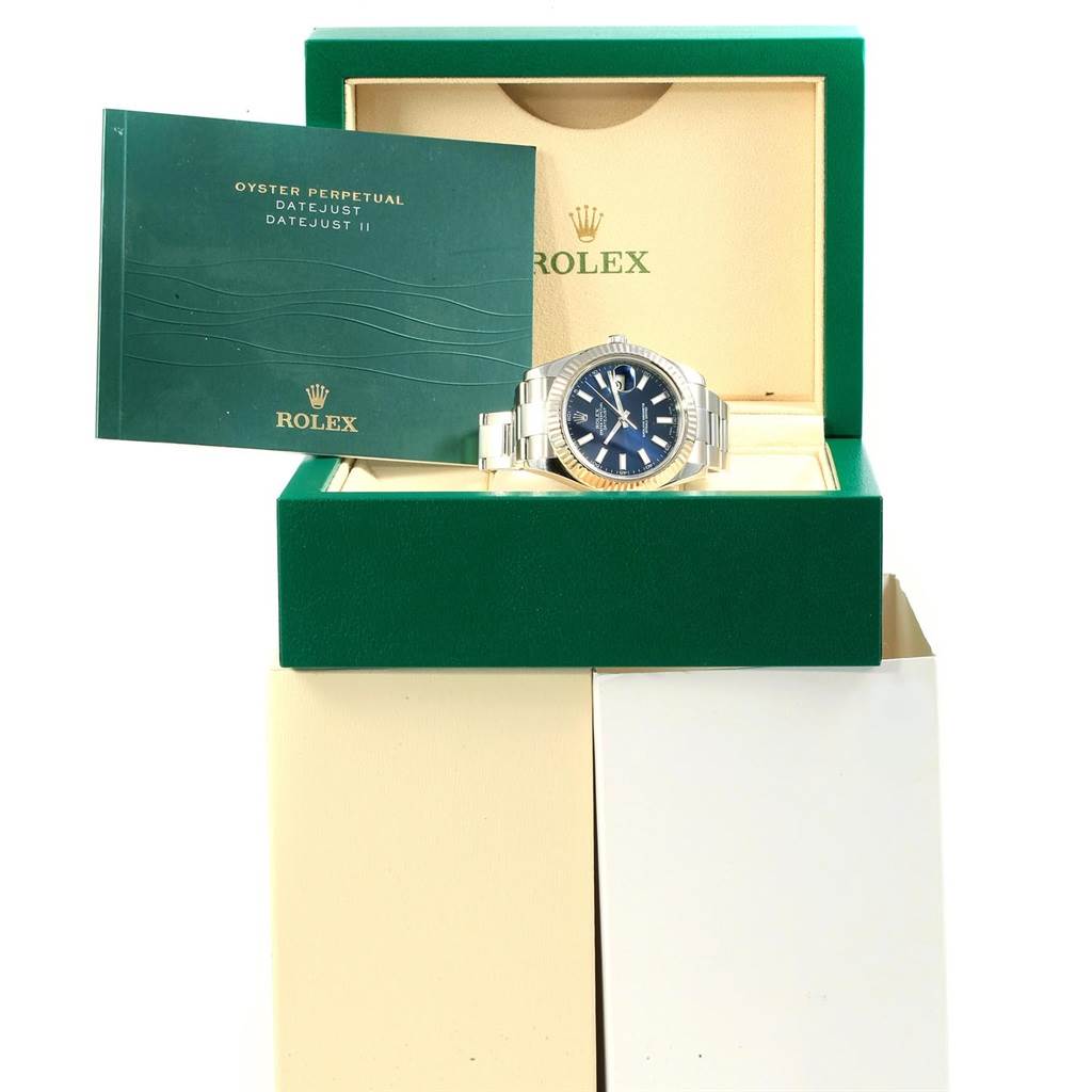 The Rolex Datejust 41 116334 Men's Stainless Steel Blue Dial 116334 Men's Stainless Steel Blue Dial watch is displayed frontally in its open box with its manual visible on the side.