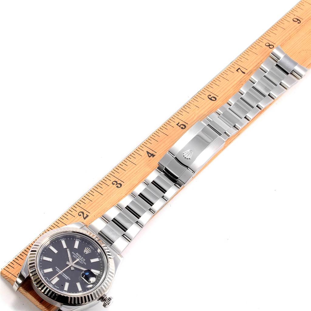 The Rolex Datejust 41 116334 Men's Stainless Steel Black Dial 116334 Men's Stainless Steel Black Dial watch is shown fully extended with a ruler for scale, displaying the face, bracelet, and clasp.