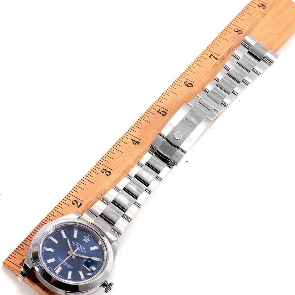 This image shows a flat-lay angle of a Rolex Datejust 41 116300 Men's Stainless Steel Blue Dial 116300 Men's Stainless Steel Blue Dial watch with a blue dial and an oyster bracelet measured against a ruler.