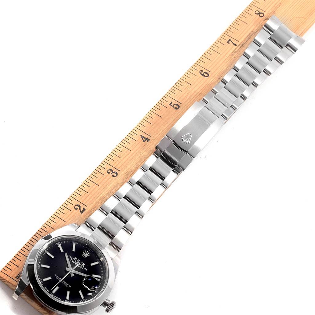 The Rolex Datejust 41 126300 Men's Stainless Steel Black Dial 126300 Men's Stainless Steel Black Dial watch is shown flat, with its bracelet fully extended alongside a ruler.