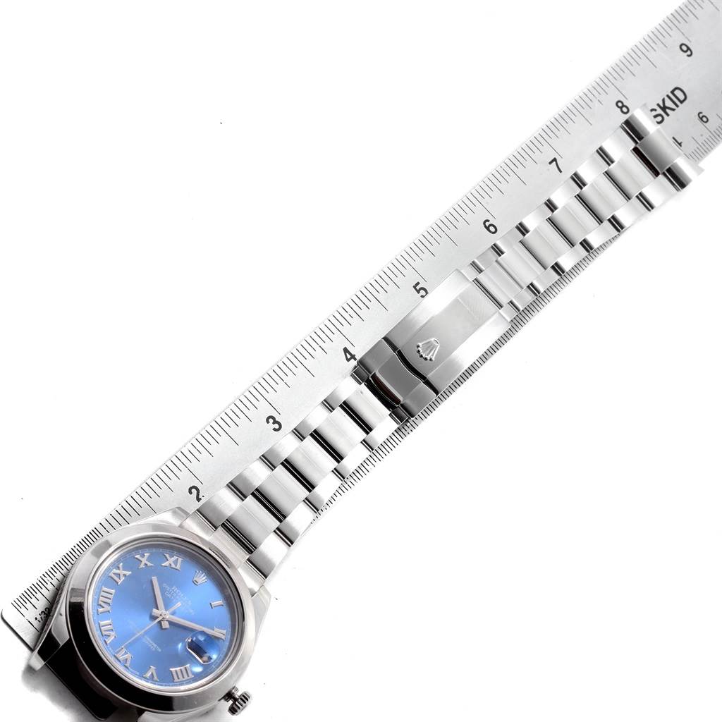 The image shows a top-down view of a Rolex Datejust 41 116300 Men's Stainless Steel Blue Dial 116300 Men's Stainless Steel Blue Dial watch, featuring its stainless steel bracelet and clasp alongside a ruler.