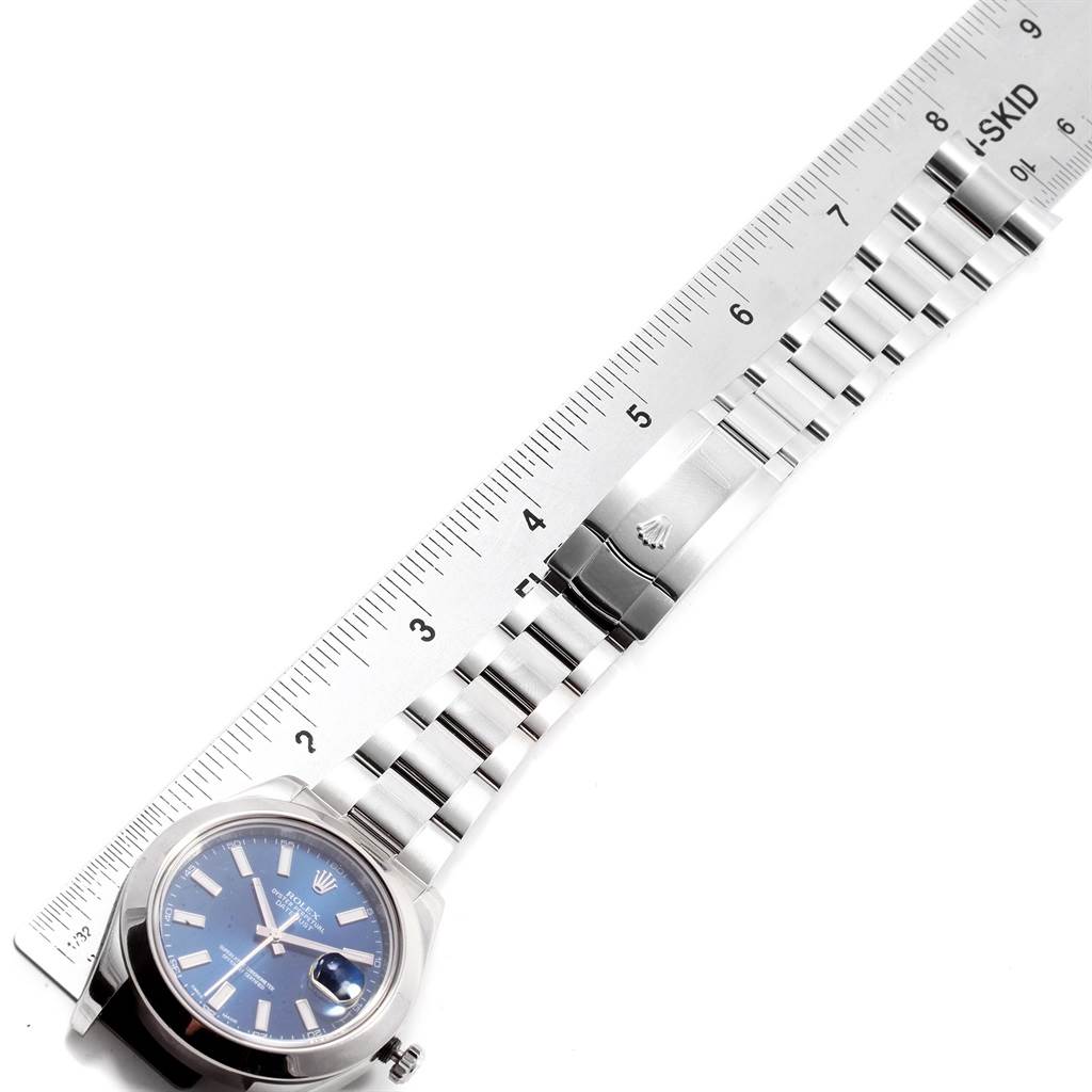 The image shows a Rolex Datejust 41 116300 Men
s Stainless Steel Blue Dial 116300 Men
s Stainless Steel Blue Dial model watch laid flat with a ruler, displaying the dial, bracelet, and clasp from a top-down angle.