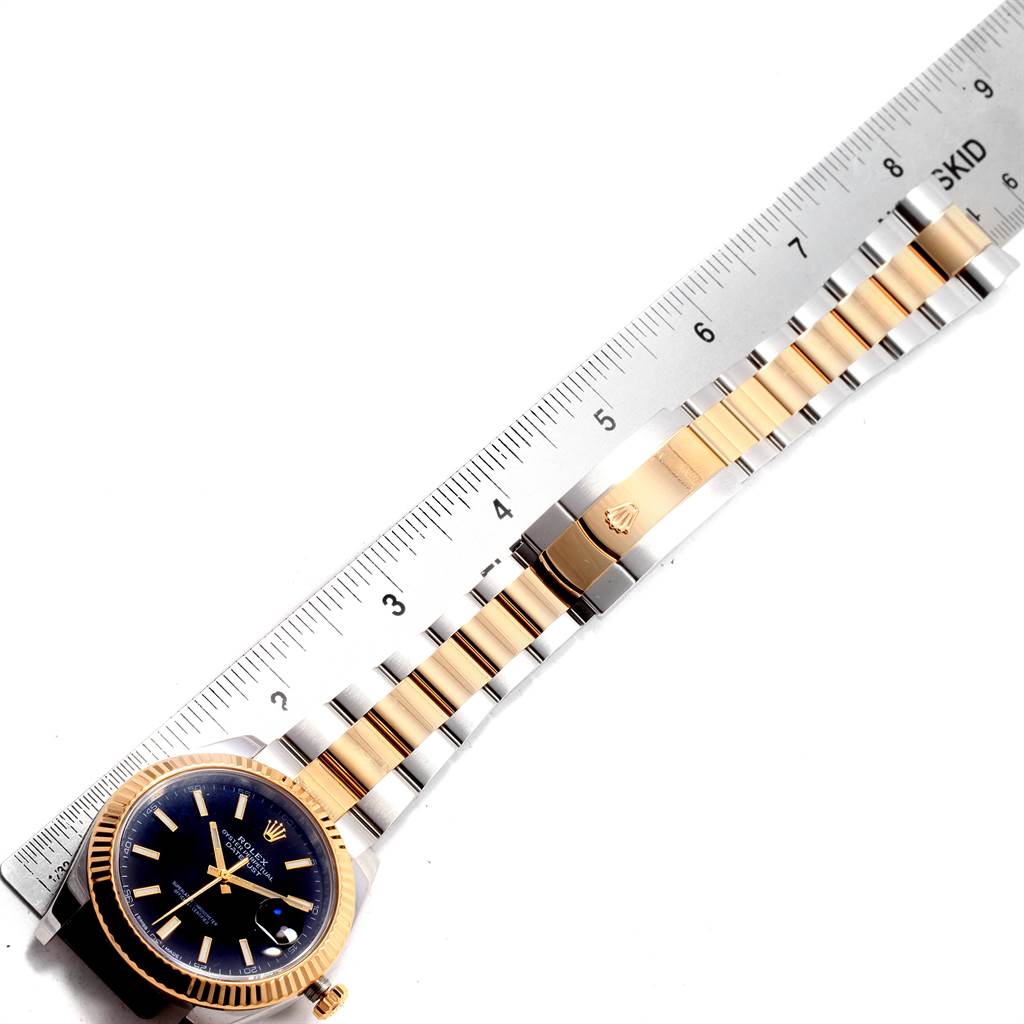 The image shows a Rolex Datejust 41 126333 Men's Steel and Gold (two tone) Black Dial 126333 Men's Steel and Gold (two tone) Black Dial watch from a top-down angle, displaying the face and the full length of the bracelet next to a ruler.