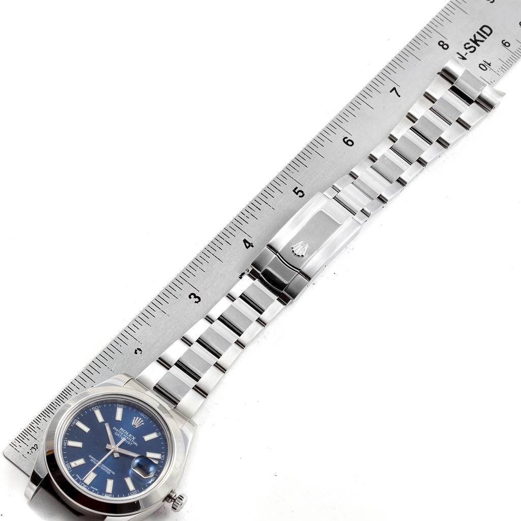 The image shows a Rolex Datejust 41 116300 Men
s Stainless Steel Blue Dial 116300 Men
s Stainless Steel Blue Dial watch with a blue dial, full bracelet, and clasp laid alongside a ruler for measurement.