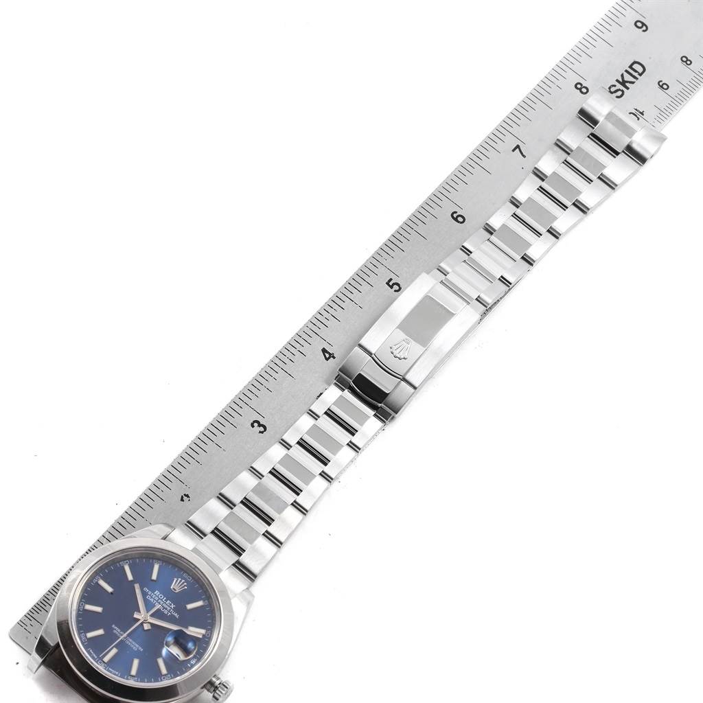 The image shows a top-down angle of a Rolex Datejust 41 126300 Men's Stainless Steel Blue Dial 126300 Men's Stainless Steel Blue Dial watch, displaying the face, bracelet, and clasp on a ruler.