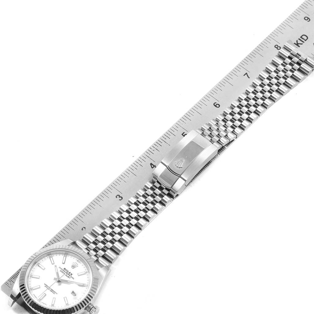 This image shows a Rolex Datejust 41 126334 Men's Stainless Steel White Dial 126334 Men's Stainless Steel White Dial watch lying flat against a ruler, displaying the face, bracelet, and clasp.
