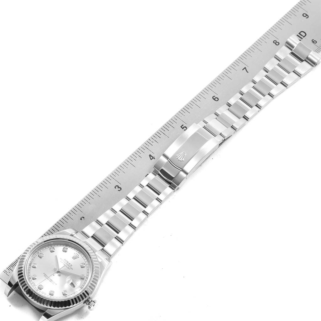 A Rolex Datejust 41 116334 Men's Stainless Steel Silver Dial 116334 Men's Stainless Steel Silver Dial watch is shown from a top-down angle, displaying the dial, bezel, bracelet, and clasp next to a ruler.
