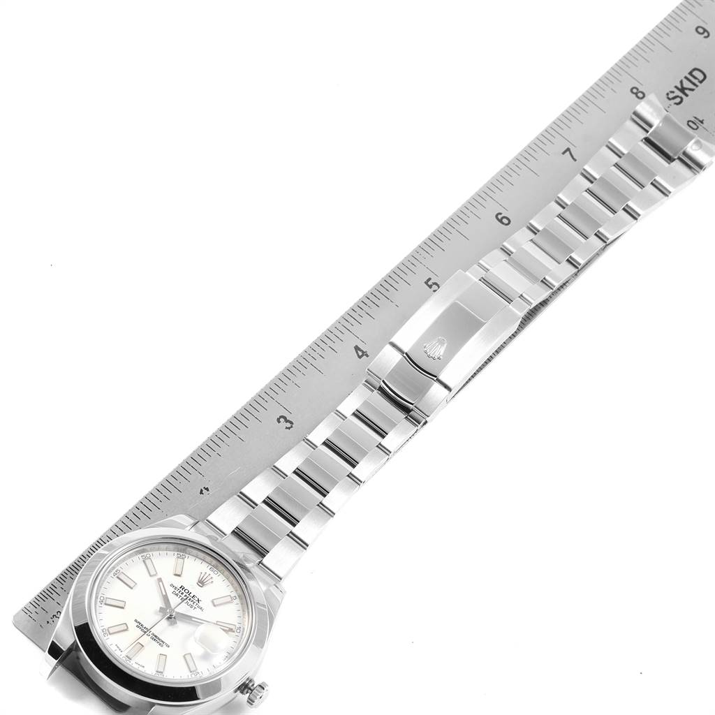 The image shows the Rolex Datejust 41 116300 Men's Stainless Steel White Dial 116300 Men's Stainless Steel White Dial watch from a top-down angle, highlighting its bracelet, clasp, and part of the dial aligned with a ruler.