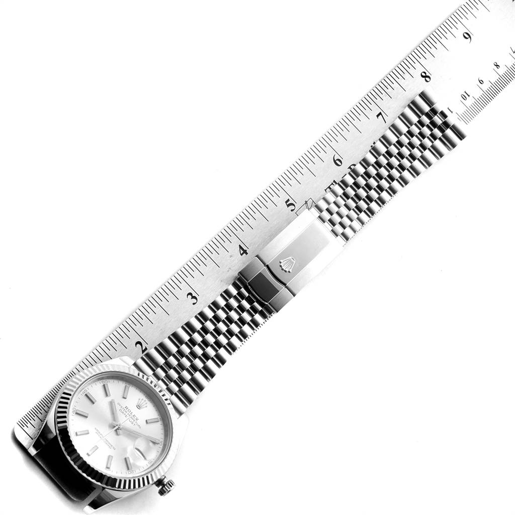 This image shows a top view of the Rolex Datejust 41 126334 Men
s Stainless Steel Silver Dial 126334 Men
s Stainless Steel Silver Dial watch with its bracelet alongside a ruler for size measurement.
