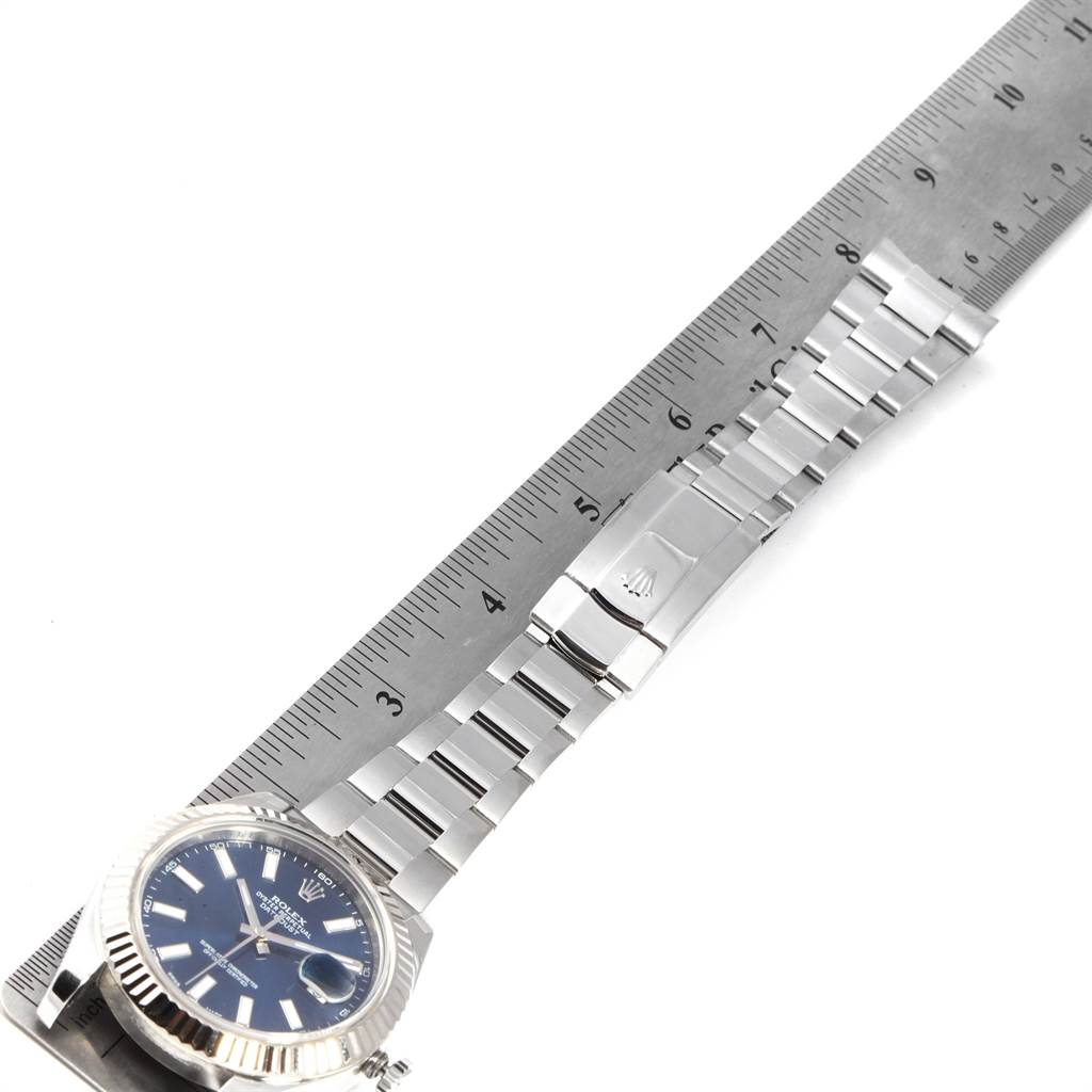 The Rolex Datejust 41 116334 Men's Stainless Steel Blue Dial 116334 Men's Stainless Steel Blue Dial watch is shown flat with its bracelet extended alongside a ruler.
