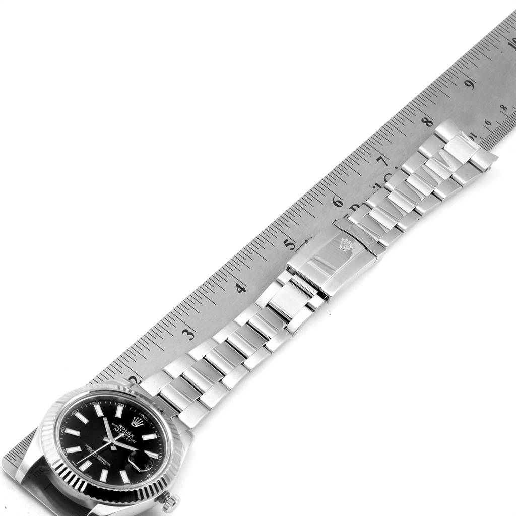 The image shows a Rolex Datejust 41 116334 Men's Stainless Steel Black Dial 116334 Men's Stainless Steel Black Dial watch laid flat against a ruler, highlighting its dial, bezel, and metal bracelet.