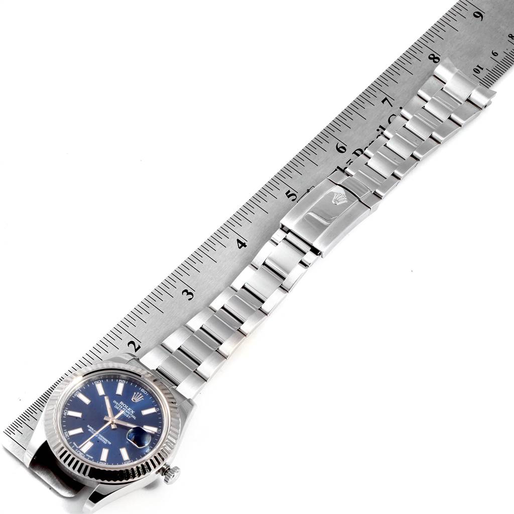 The image shows the Rolex Datejust 41 116334 Men's Stainless Steel Blue Dial 116334 Men's Stainless Steel Blue Dial watch laying flat with its band extended alongside a ruler for measurement.